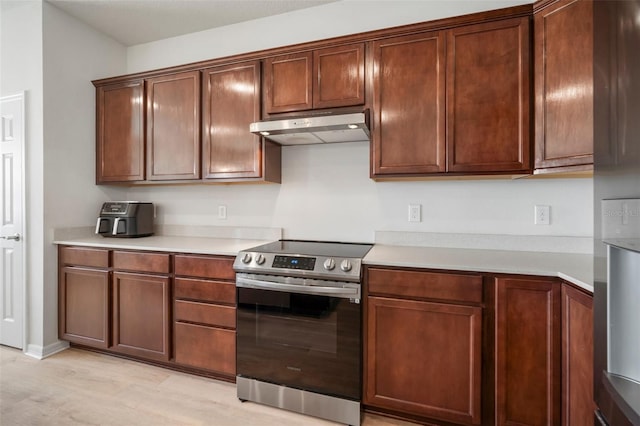 kitchen with light countertops, electric range, and under cabinet range hood