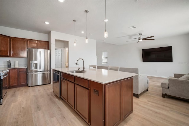 kitchen featuring visible vents, a sink, stainless steel appliances, light countertops, and ceiling fan