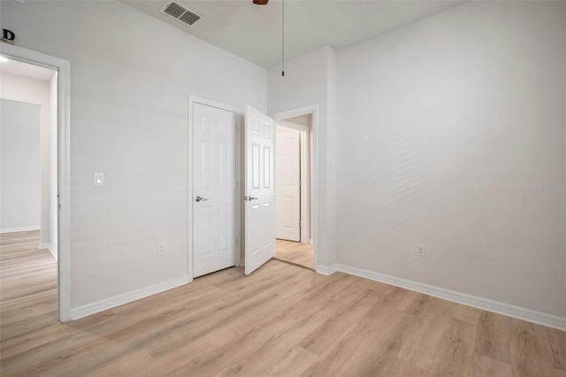 unfurnished bedroom featuring light wood-type flooring, visible vents, baseboards, and ceiling fan