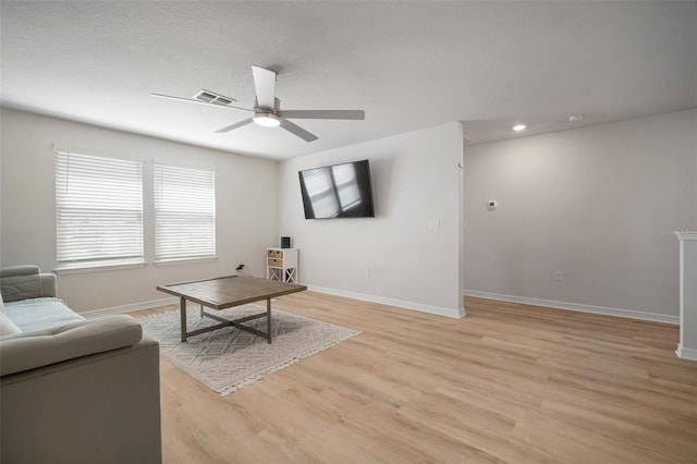 living room featuring visible vents, baseboards, recessed lighting, light wood-style floors, and a ceiling fan