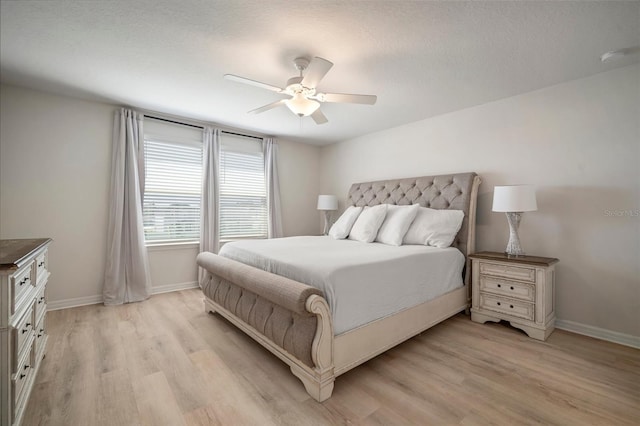 bedroom featuring light wood-type flooring, baseboards, and a ceiling fan