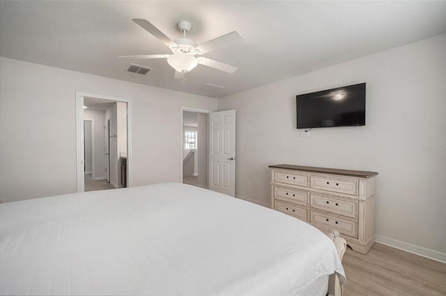 bedroom featuring visible vents, baseboards, light wood-style floors, and ceiling fan