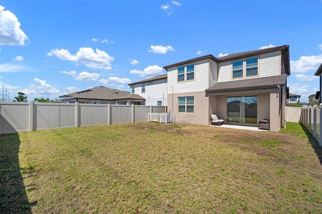 back of property with a lawn, a patio, a fenced backyard, and stucco siding