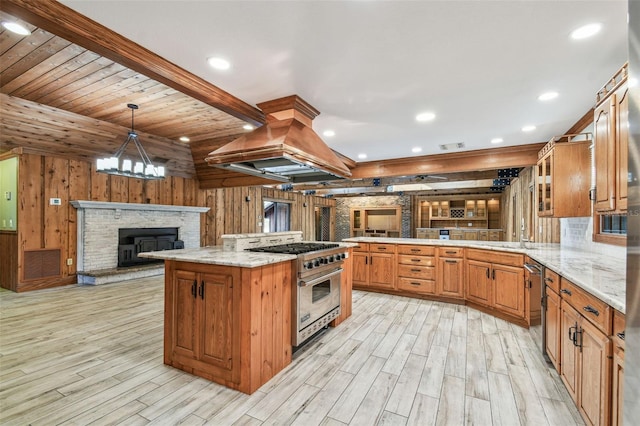 kitchen featuring open floor plan, wood walls, appliances with stainless steel finishes, and a peninsula
