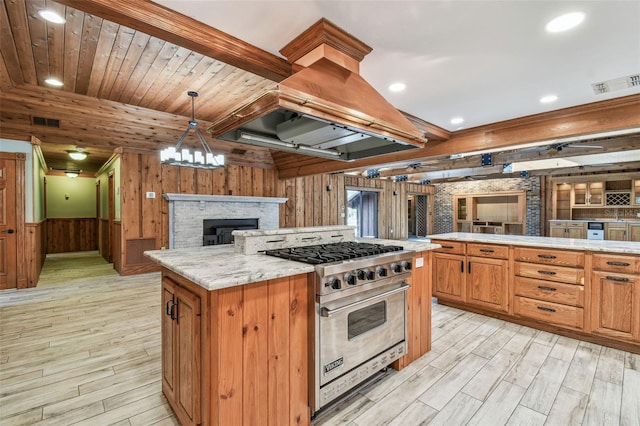 kitchen featuring visible vents, island exhaust hood, open floor plan, premium range, and light wood finished floors