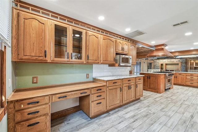 kitchen featuring island exhaust hood, stainless steel appliances, visible vents, and light wood finished floors