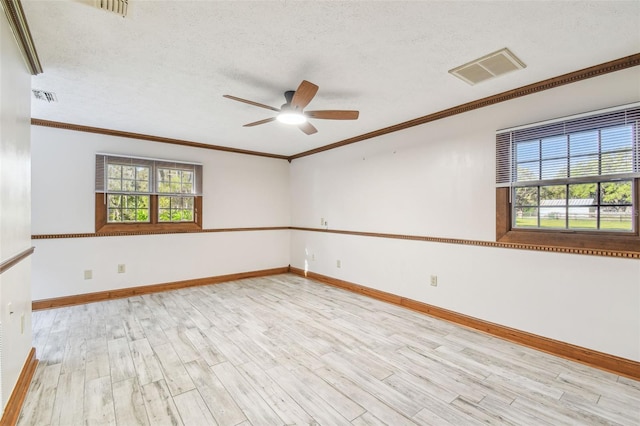 unfurnished room with a ceiling fan, wood finished floors, visible vents, ornamental molding, and a textured ceiling