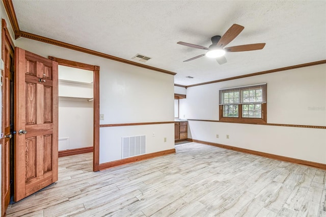 spare room with visible vents, light wood-style floors, and a ceiling fan