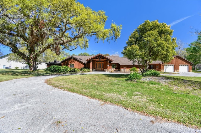 view of front of house featuring driveway, an attached garage, and a front lawn