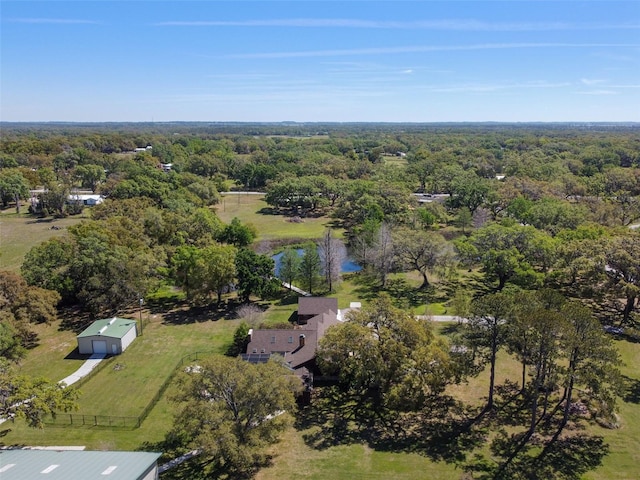 birds eye view of property featuring a water view and a wooded view