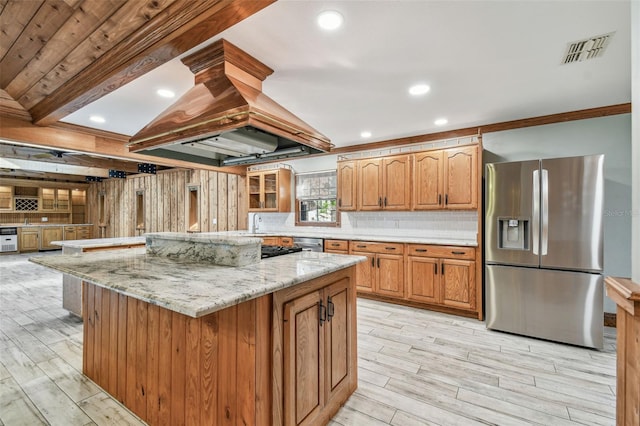 kitchen with island exhaust hood, visible vents, light wood-style floors, and appliances with stainless steel finishes