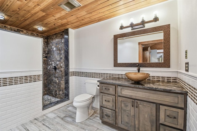 bathroom with tile walls, toilet, wood ceiling, and wainscoting