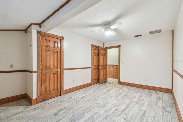 empty room with visible vents, ceiling fan, and wood finished floors