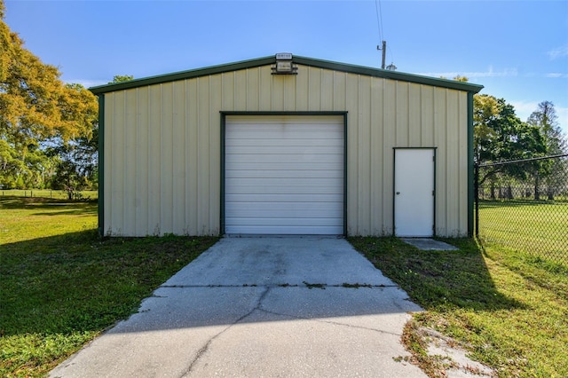 detached garage with concrete driveway and fence