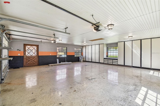 garage with a garage door opener and concrete block wall