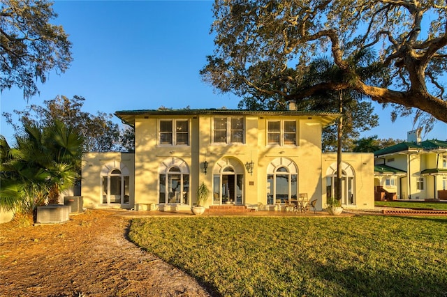 view of front of house featuring central AC unit, stucco siding, and a front lawn