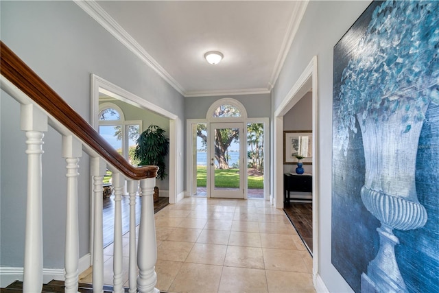 foyer with light tile patterned floors, stairway, crown molding, and baseboards