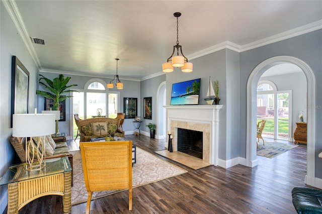 living room featuring arched walkways, visible vents, plenty of natural light, and wood finished floors