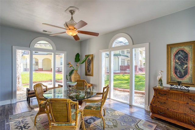 dining room featuring visible vents, baseboards, wood finished floors, and a ceiling fan