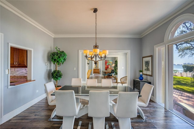 dining room featuring a notable chandelier, dark wood-type flooring, baseboards, and ornamental molding