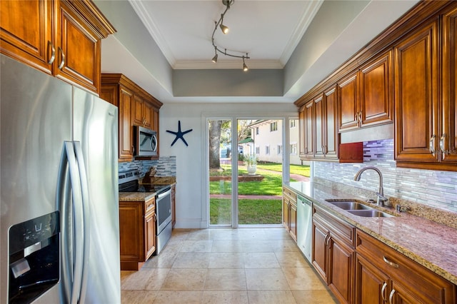 kitchen with a sink, stainless steel appliances, light stone countertops, and crown molding