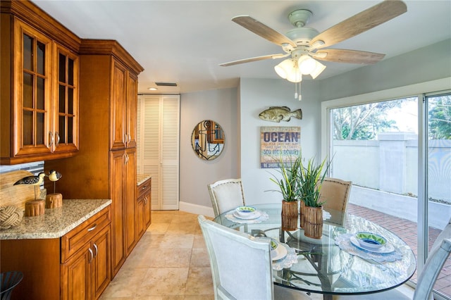 dining room with light tile patterned floors, baseboards, and a ceiling fan