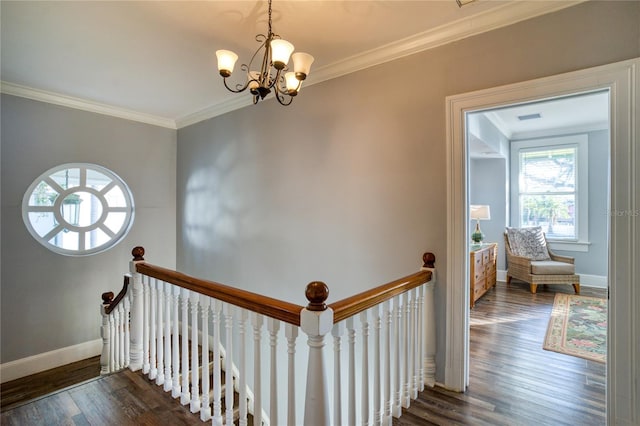 staircase featuring visible vents, a notable chandelier, ornamental molding, wood finished floors, and baseboards