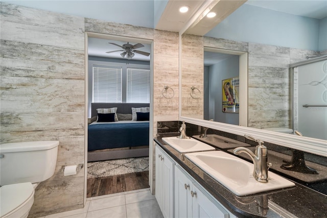 full bathroom featuring connected bathroom, ceiling fan, toilet, tile patterned floors, and a sink