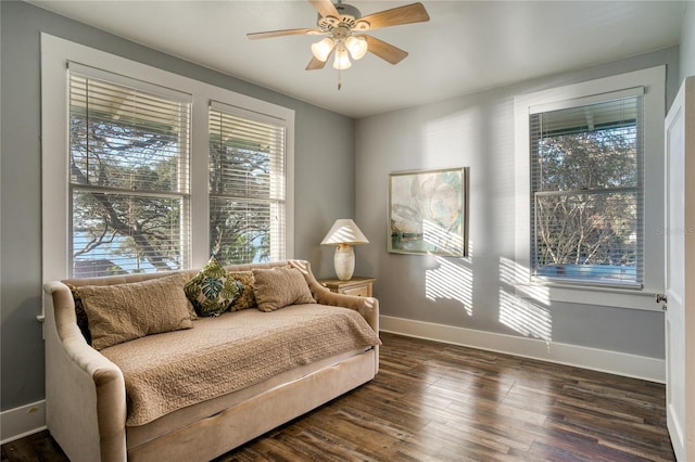 sitting room with baseboards, ceiling fan, and wood finished floors