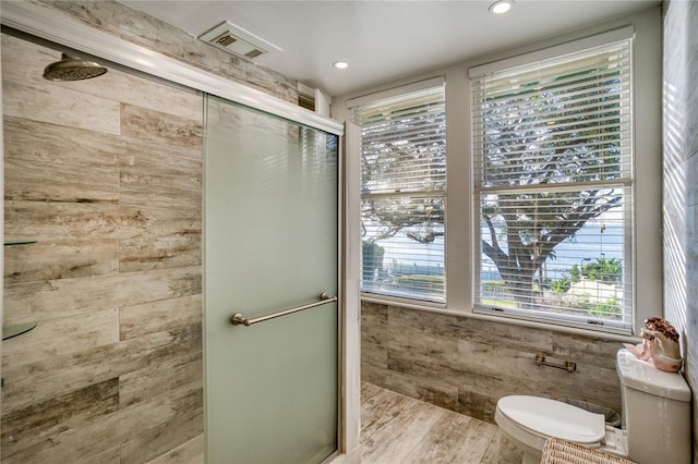 full bath with visible vents, a shower stall, toilet, and wood finished floors