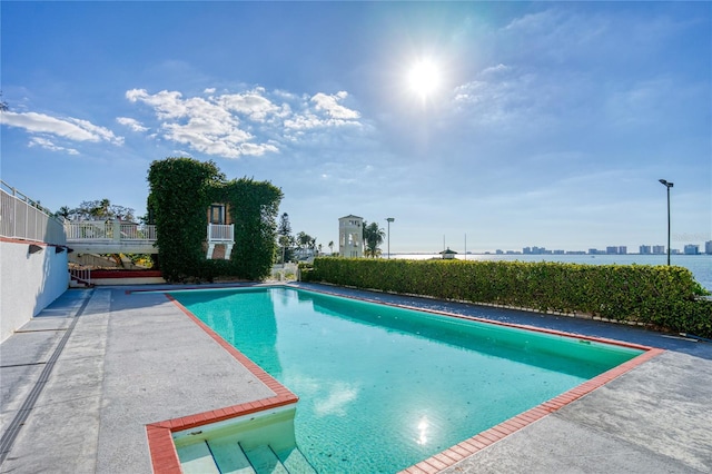 view of swimming pool with a city view, a fenced in pool, and fence