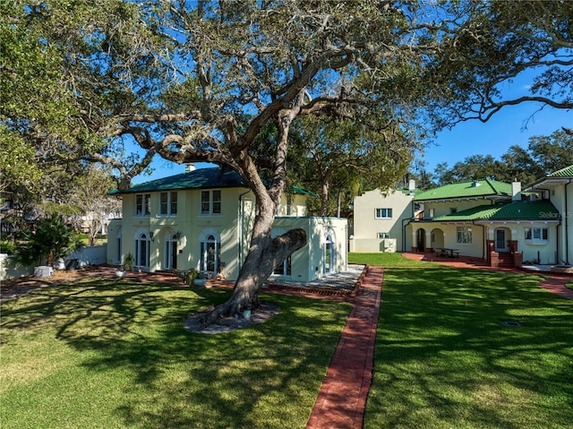 exterior space featuring a patio, a lawn, and stucco siding