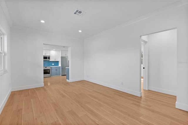 unfurnished living room featuring baseboards, crown molding, and light wood-style flooring