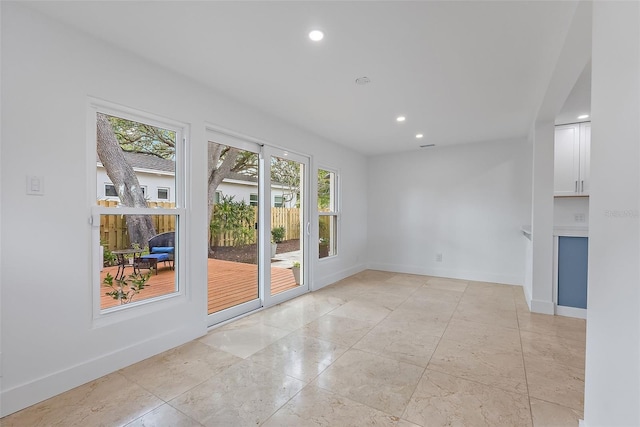 unfurnished room with baseboards and recessed lighting
