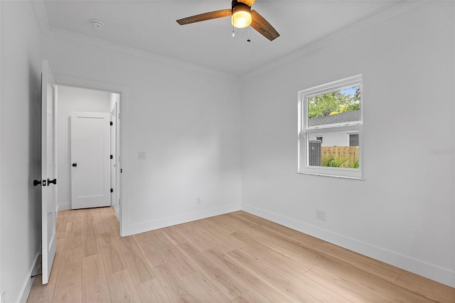 empty room with baseboards, ceiling fan, light wood-style floors, and crown molding