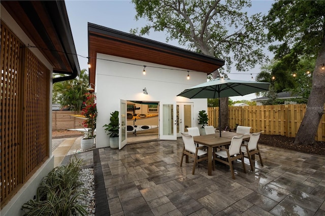 view of patio featuring outdoor dining area, fence, and french doors