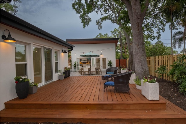 deck with fence, outdoor dining space, and french doors