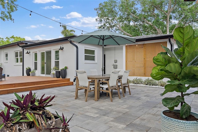 view of patio featuring outdoor dining area, a wooden deck, and french doors
