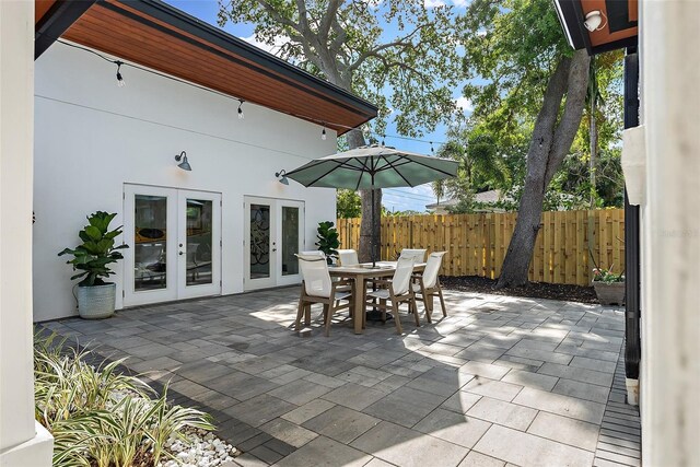 view of patio featuring outdoor dining space, fence, and french doors