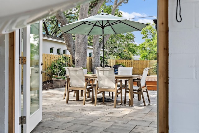 view of patio featuring outdoor dining area and fence