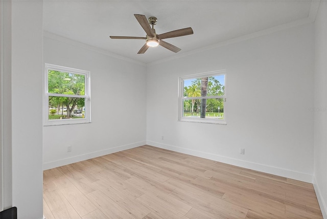 spare room with baseboards, light wood-type flooring, crown molding, and ceiling fan