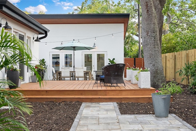 wooden terrace featuring fence and french doors