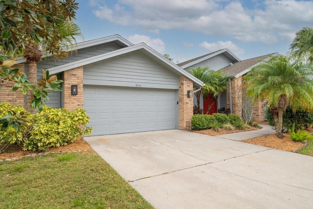 view of front of property featuring a garage, brick siding, and concrete driveway