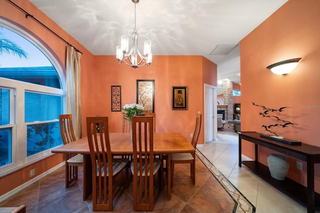 dining space with an inviting chandelier, light tile patterned flooring, and baseboards