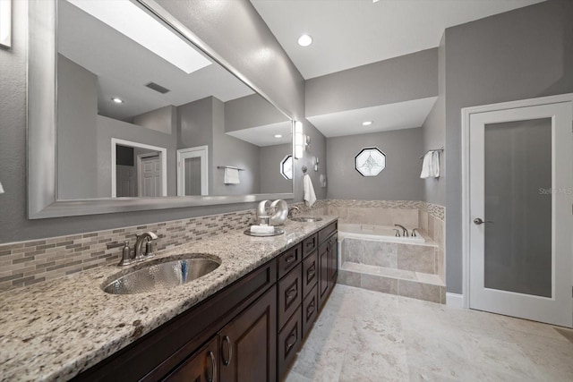 full bath featuring a garden tub, tasteful backsplash, visible vents, and a sink