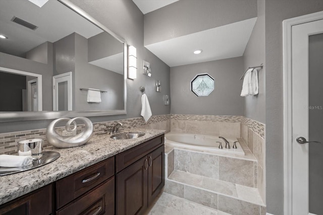 bathroom featuring a bath, visible vents, backsplash, and vanity