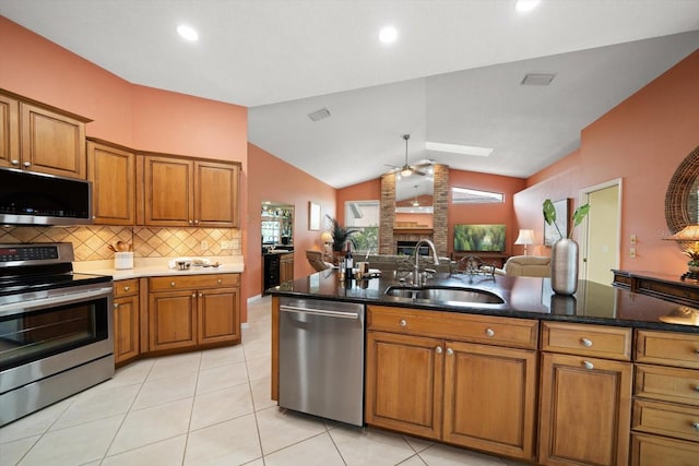 kitchen featuring a ceiling fan, brown cabinetry, appliances with stainless steel finishes, and a sink