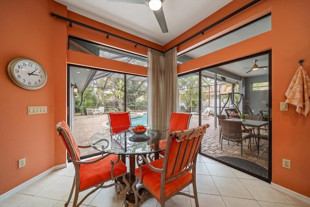 tiled dining room with a ceiling fan, baseboards, and a sunroom