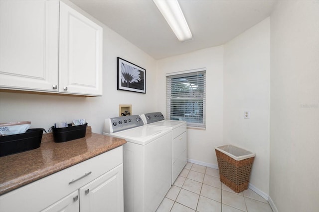 laundry room featuring washer and clothes dryer, light tile patterned floors, cabinet space, and baseboards