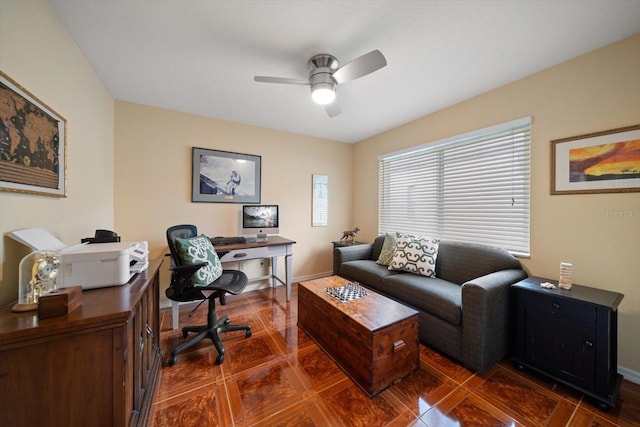 office space with dark tile patterned floors, baseboards, and ceiling fan